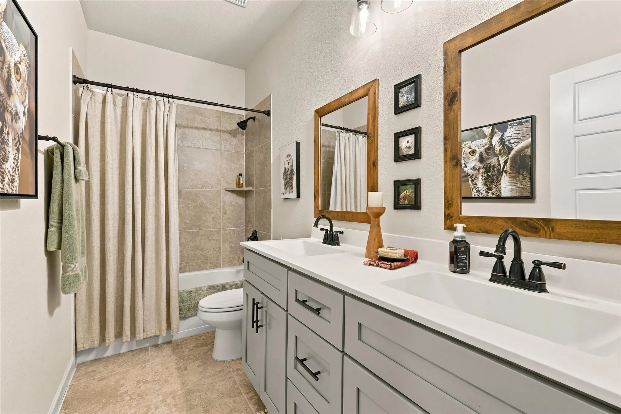A beautifully finished full bath features dual sinks, generous counter space, modern cabinetry and a tiled tub/shower combination.
