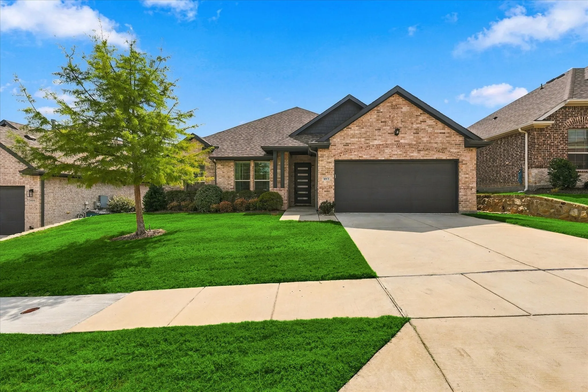 Striking curb appeal from the very first glance—beautiful brick, modern architectural details, lush lawn and a welcoming covered entry set the tone for what’s inside.