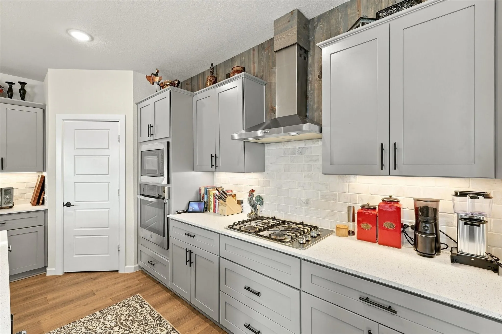 A kitchen designed to impress—sleek cabinetry, quartz-style counters, stainless appliances, modern black hardware and an expansive island combine style with serious functionality.