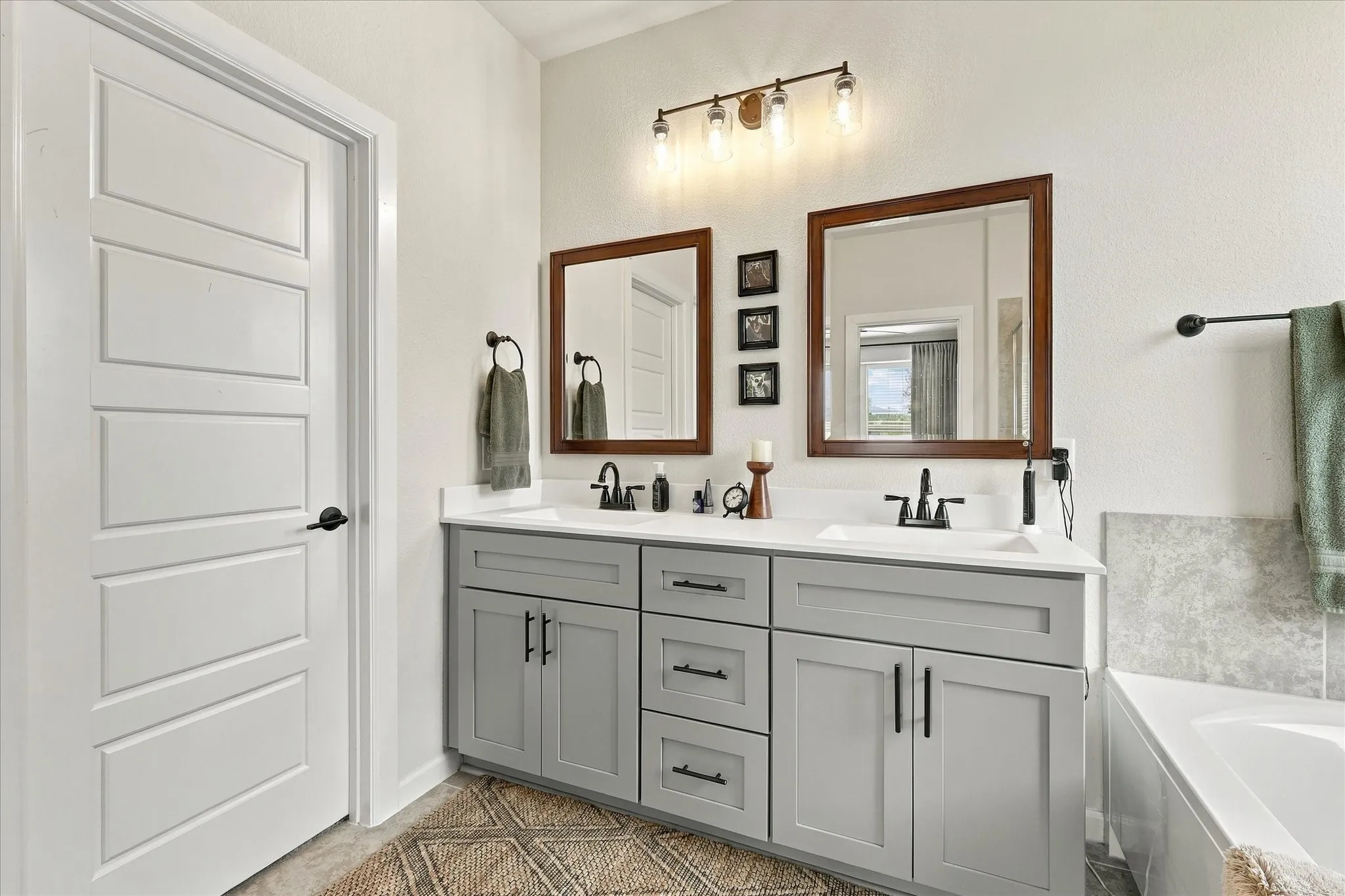 The expansive dual-sink vanity offers outstanding storage and counter space, complemented by warm finishes and stylish fixtures.