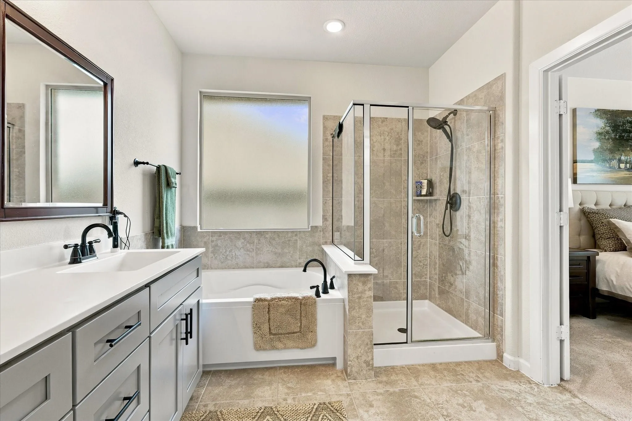 The primary bath combines comfort and function with a large soaking tub, separate shower and bright natural light.