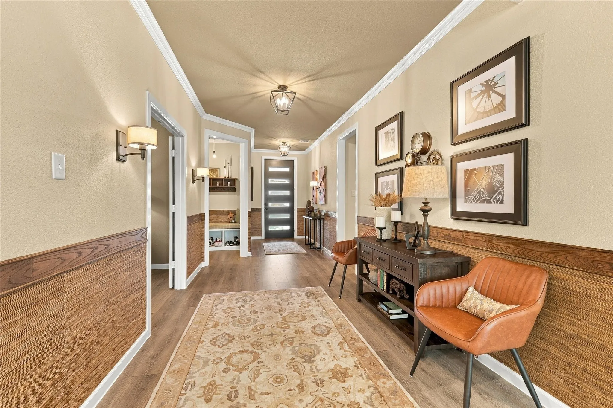 Distinctive details are everywhere—from custom-style wall treatments and warm wood tones to elegant lighting that gives the entry a truly memorable feel.