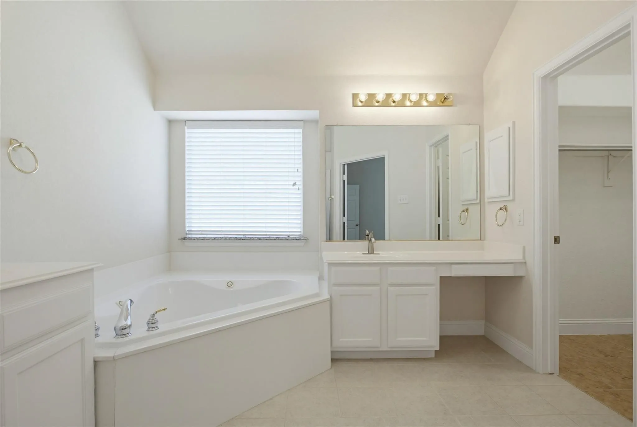 Corner soaking tub with polished chrome fixtures
