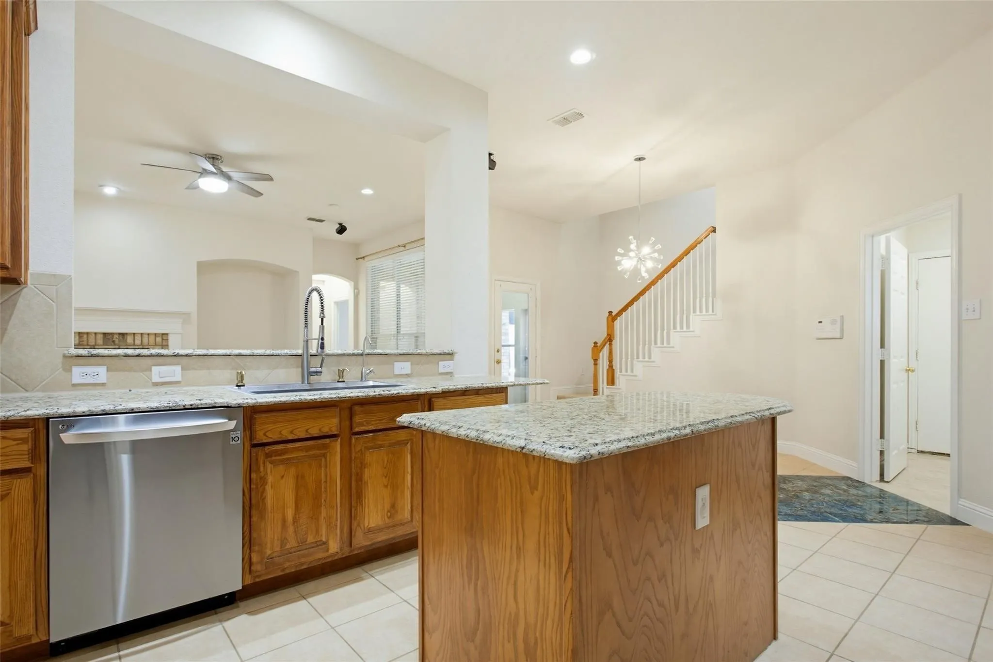Kitchen featuring wood cabinetry, granite countertops, tile flooring, and stainless steel appliances