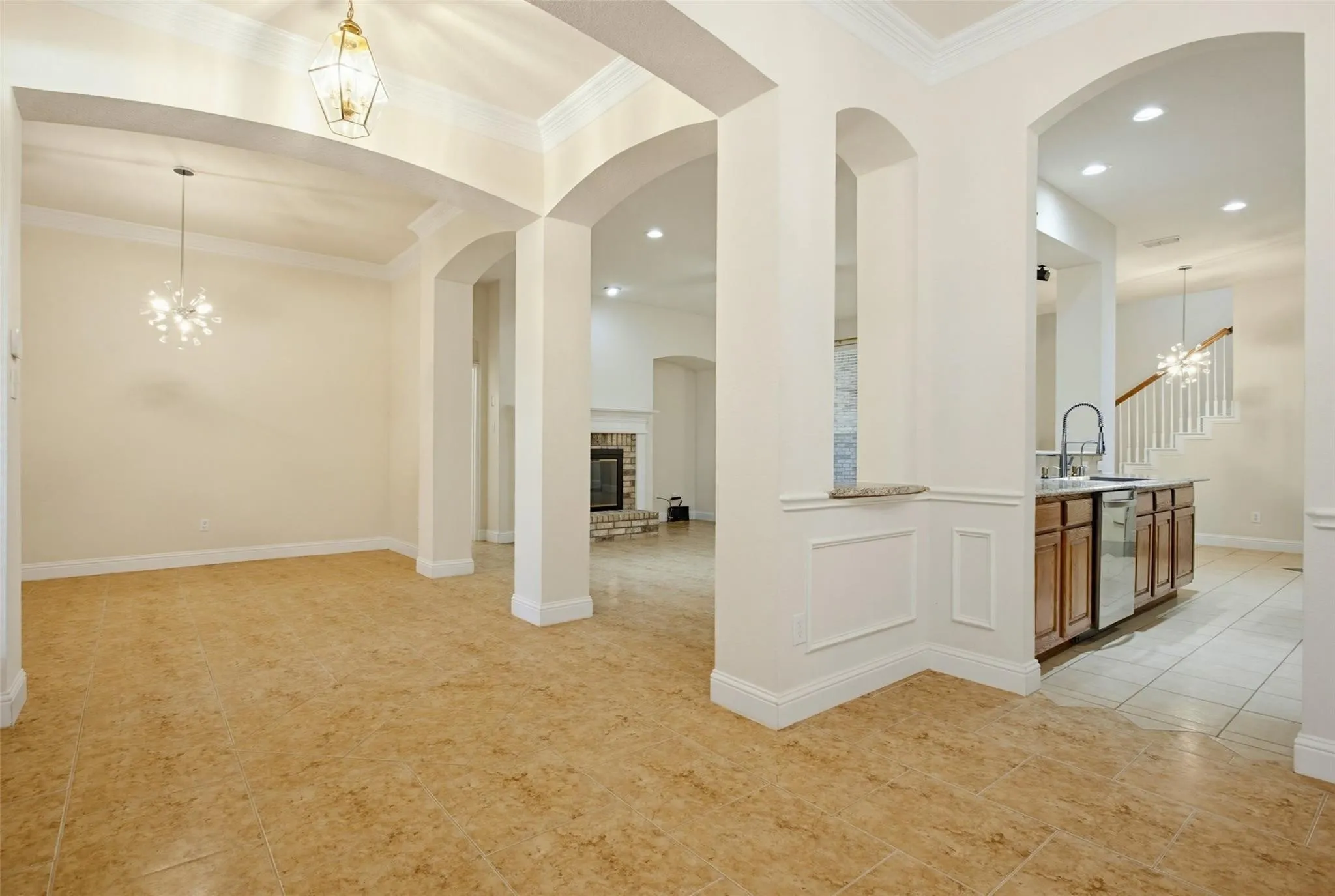 Arched doorways, crown molding, and tile flooring create an elegant interior