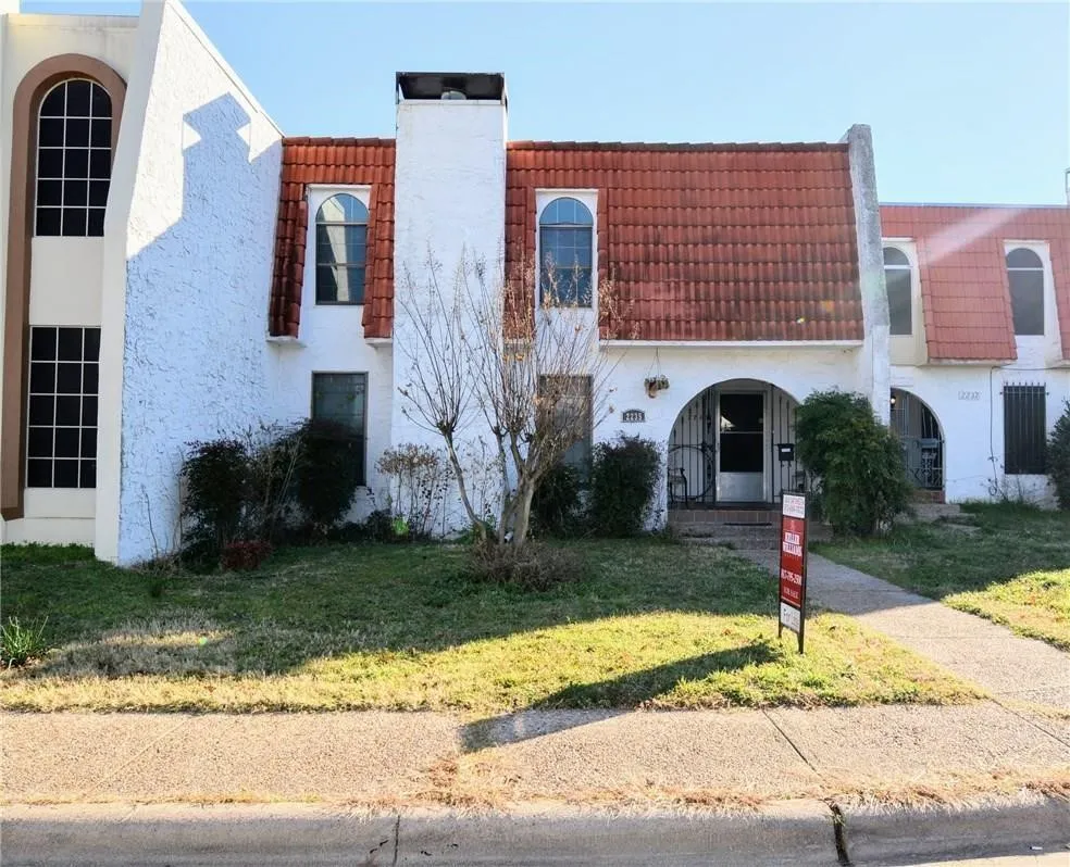 White stucco exterior with a prominent red tile roof