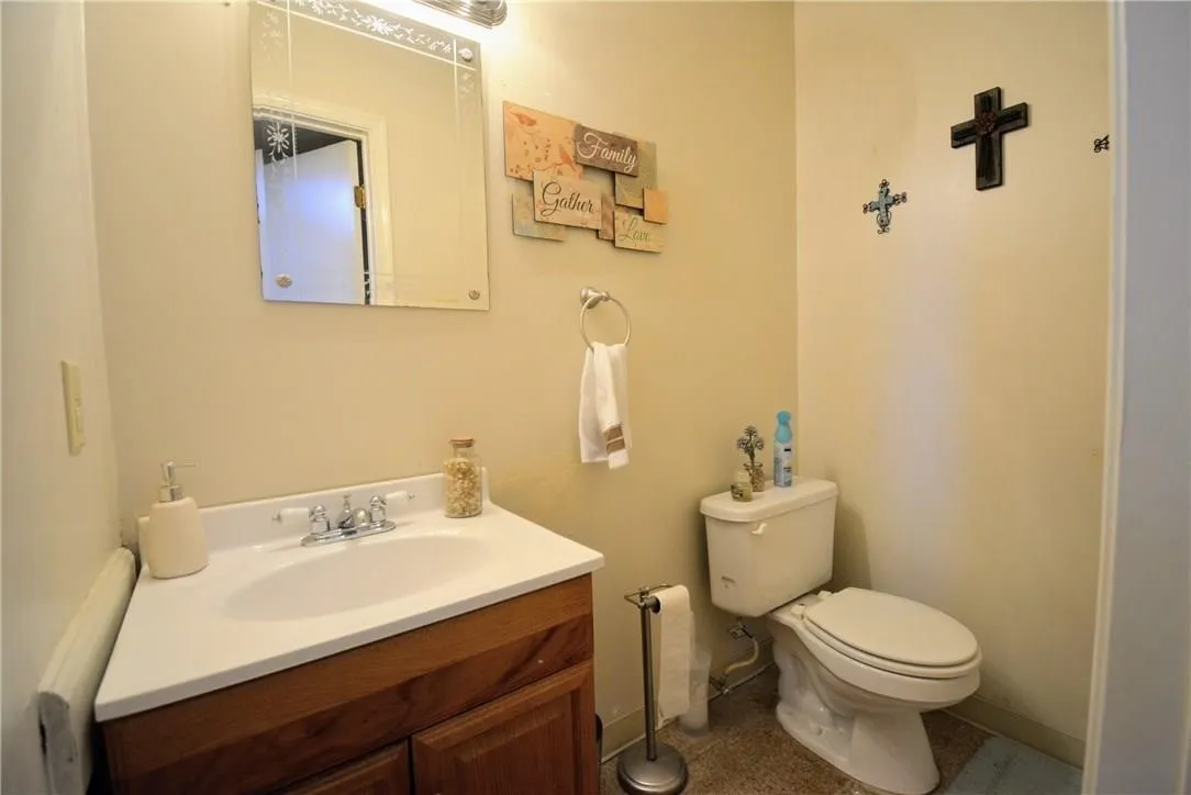Corner vanity with a white countertop and wood-finish cabinetry