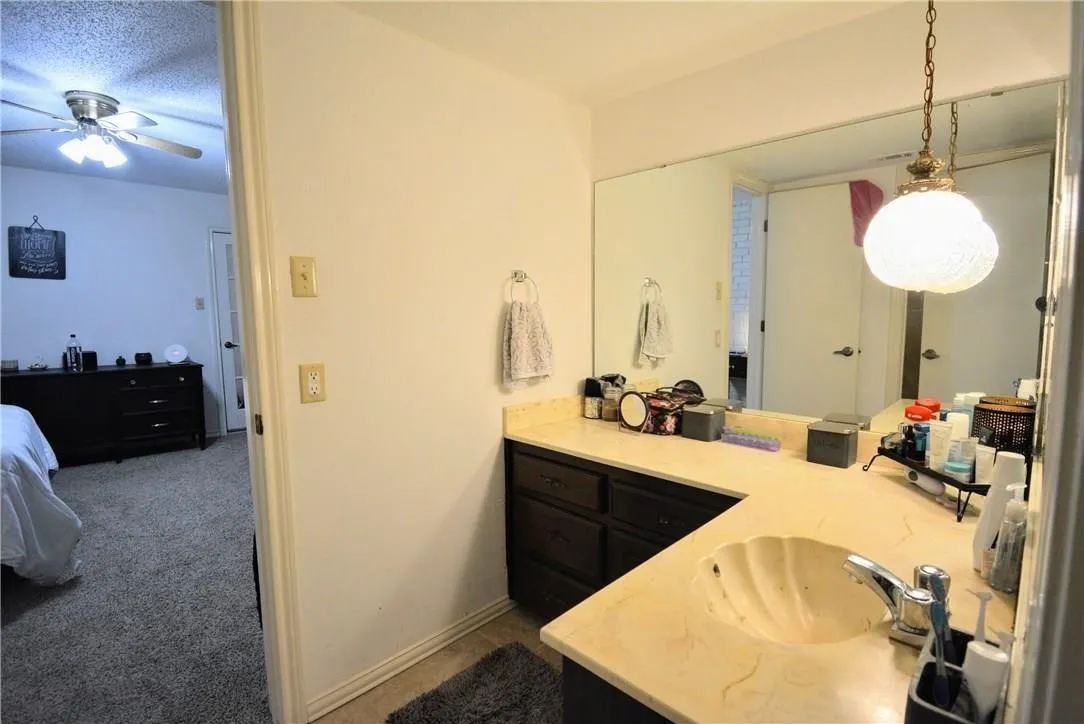 Vanity with a shell-design sink, chrome faucet, and expansive mirror