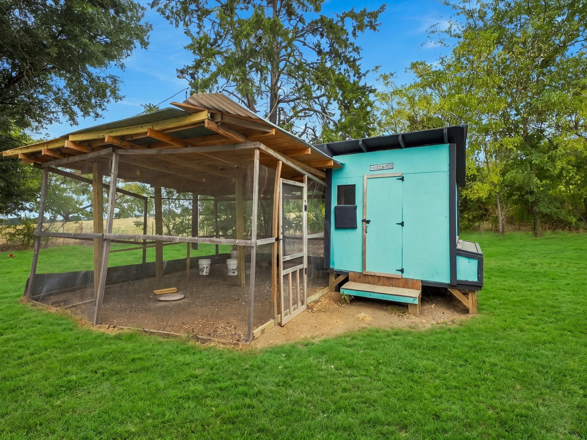 Outdoor structure featuring a screened enclosure and a detached teal-painted shed