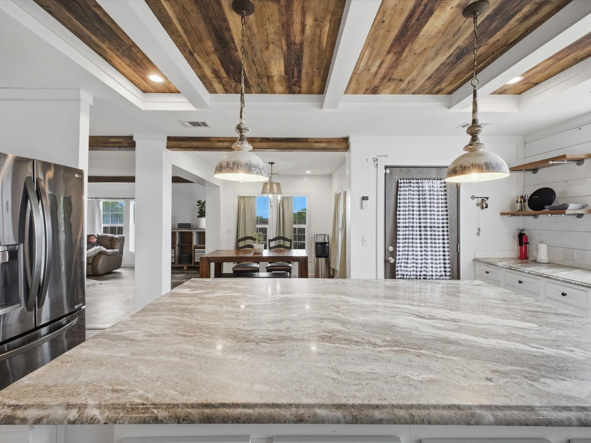 Tray ceiling with wood-finish planks, recessed lighting, and decorative pendant fixtures