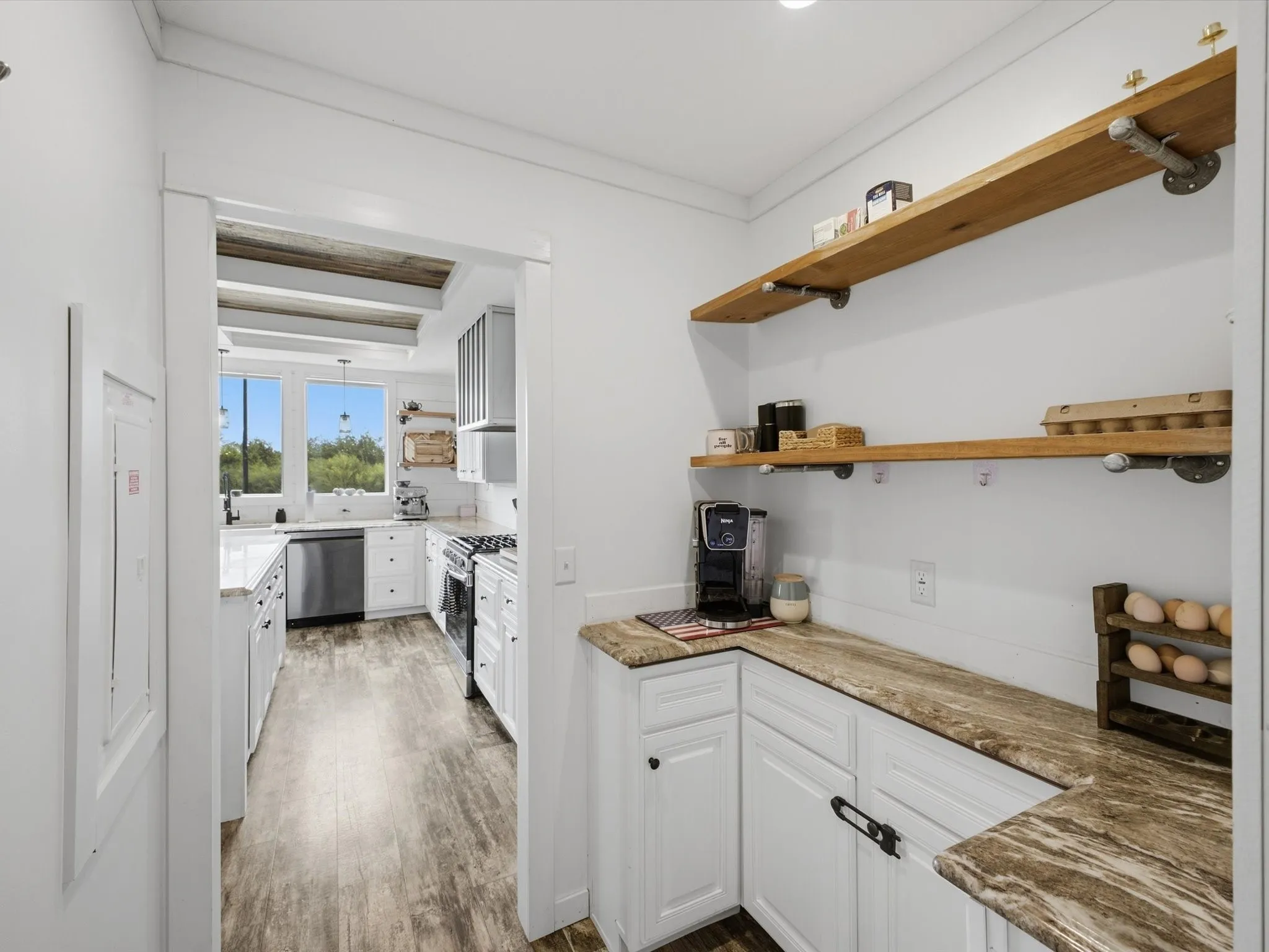 Built-in pantry cabinetry with a stone-finish countertop, open wood shelving, and wood-finish flooring