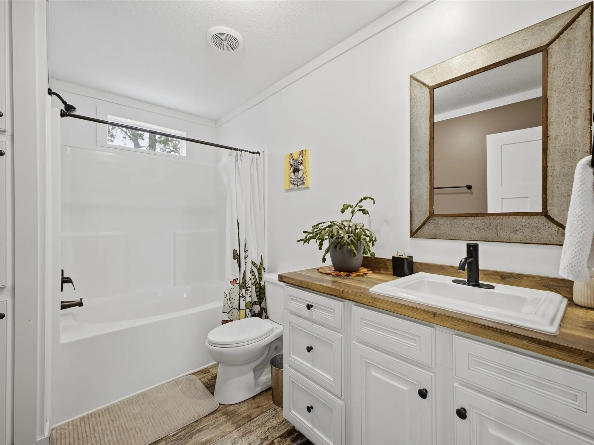 White vanity with wood-finish countertop, rectangular undermount sink, and matte black faucet