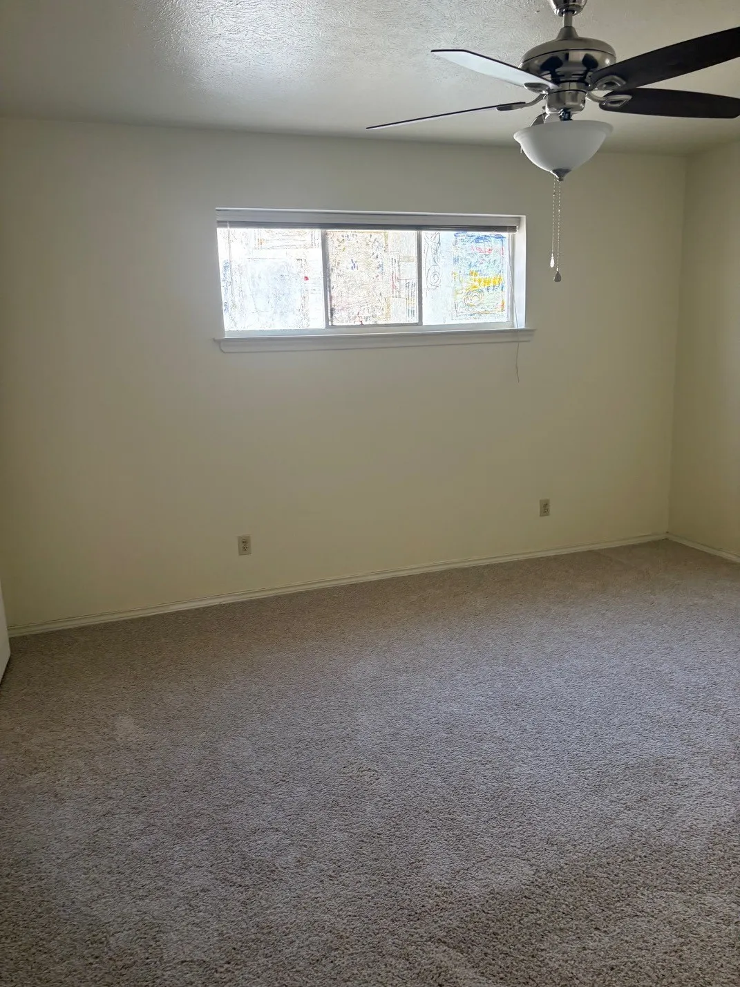 Wall-to-wall carpeting and a ceiling fan with integrated lighting