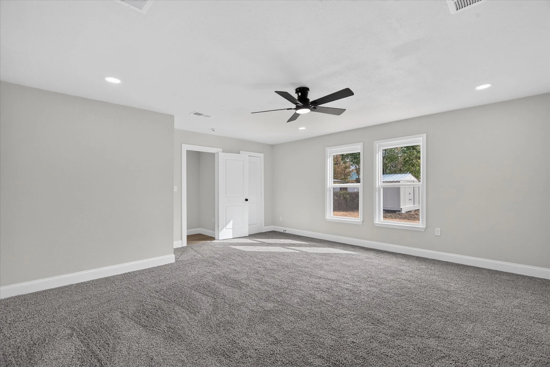 Spacious room featuring neutral carpeting and light gray walls