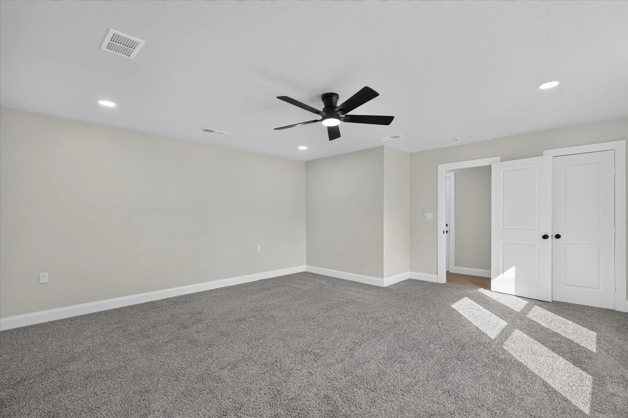 Carpeted room with recessed lighting, a ceiling fan, white trim, and white bi-fold doors