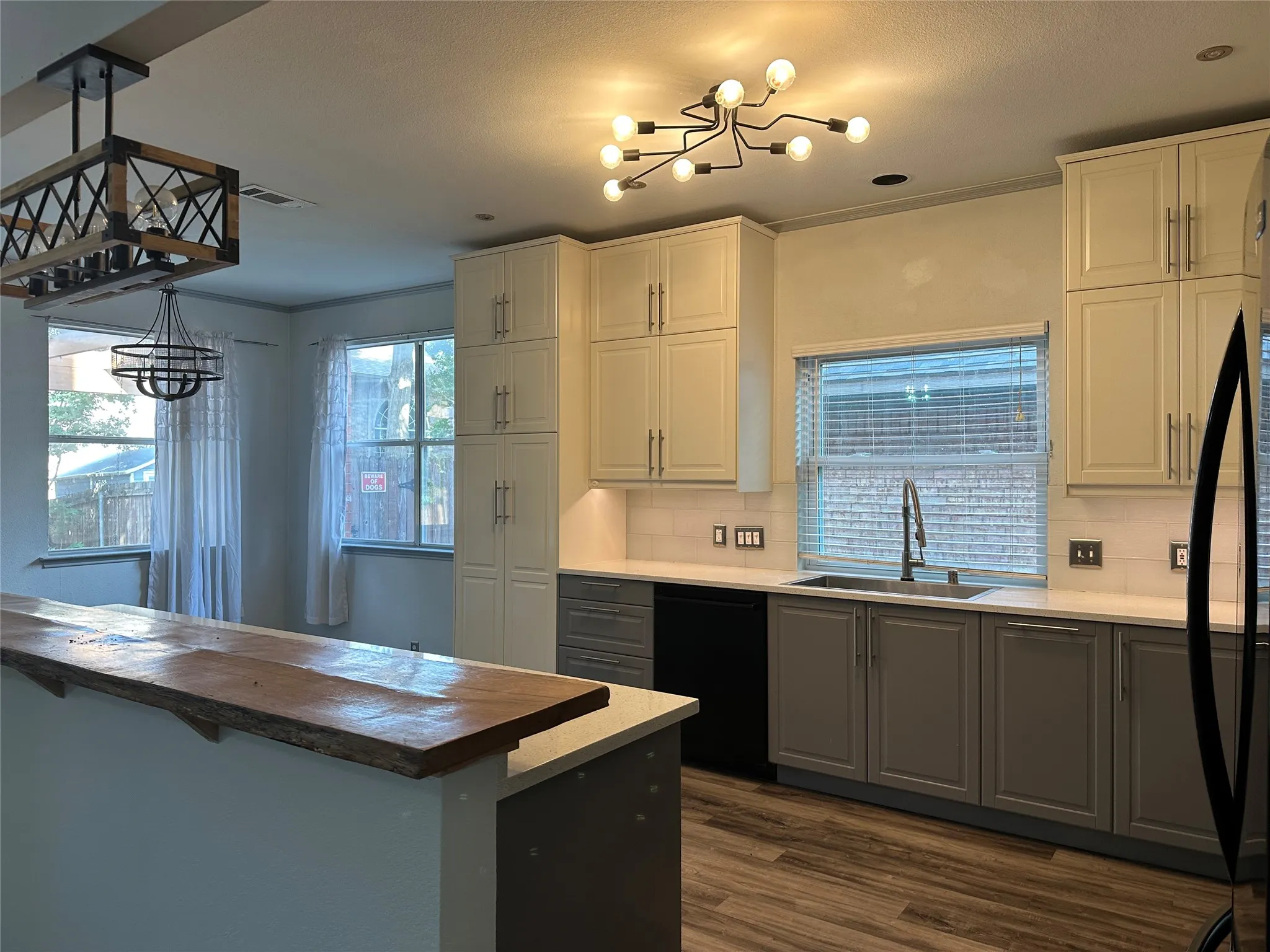 Two-tone cabinetry with an integrated dishwasher, undermount sink, and light countertops