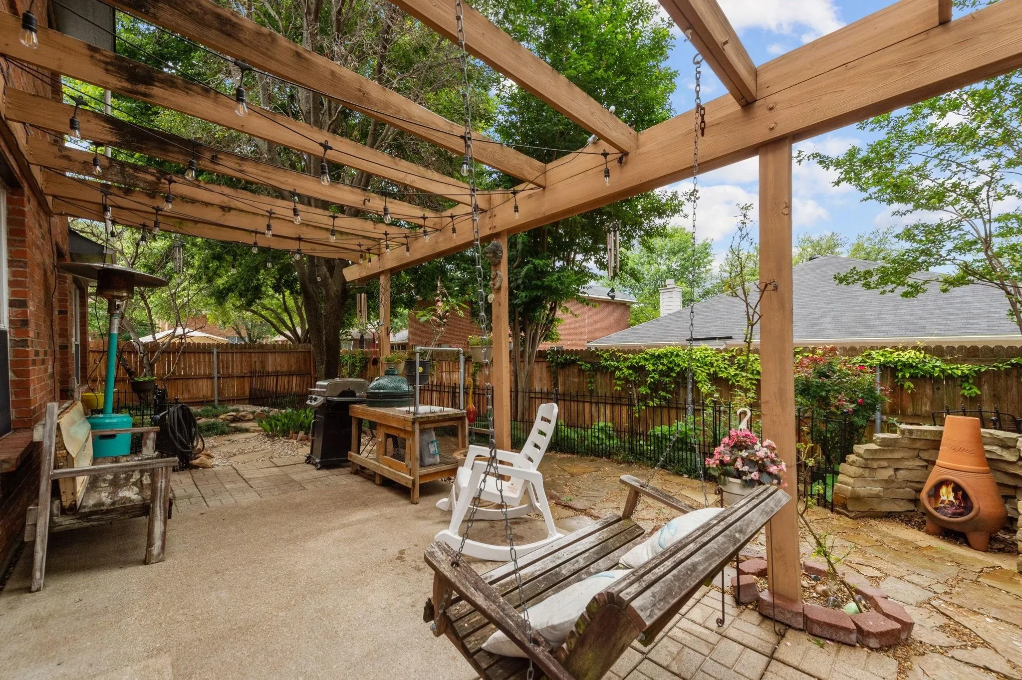  patio featuring a wood-beam pergola, string lighting, and brick-laid and concrete flooring