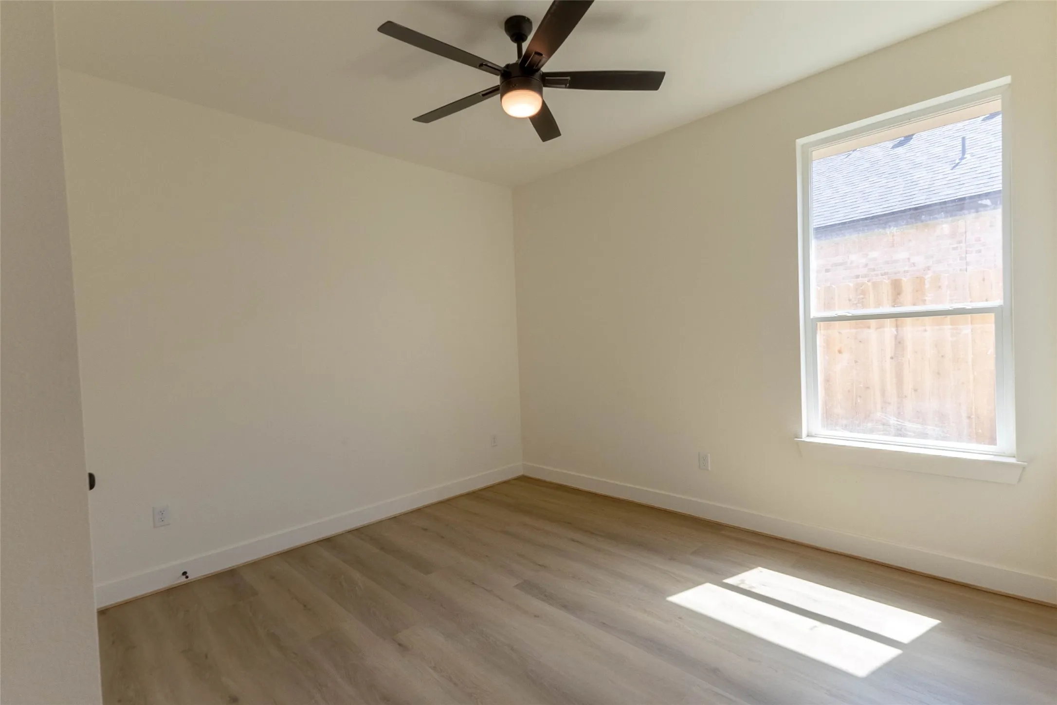 Wood-finish flooring, single window, flush-mount ceiling fan with integrated lighting