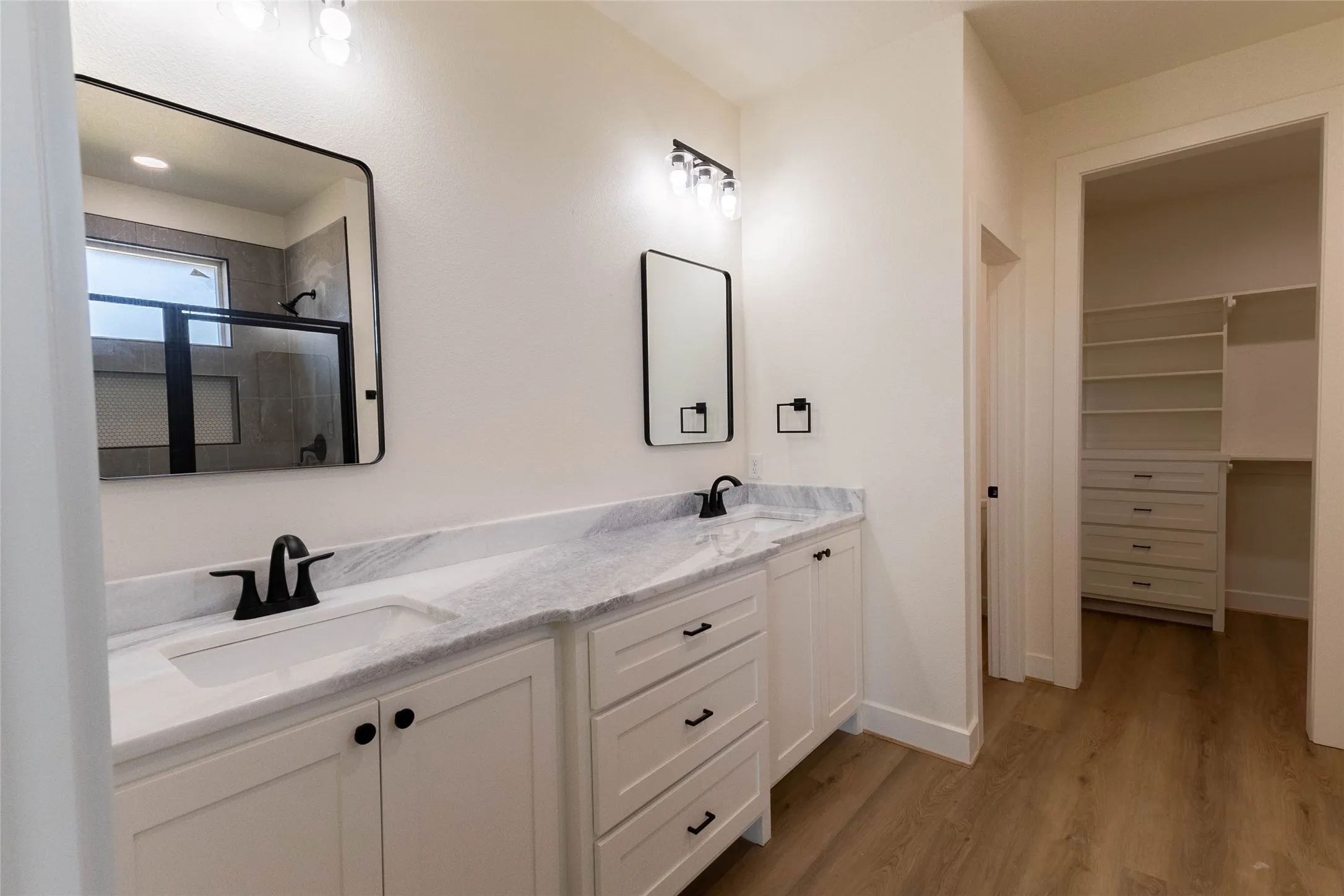 Dual vanity with white cabinetry, integrated sinks, and counter space