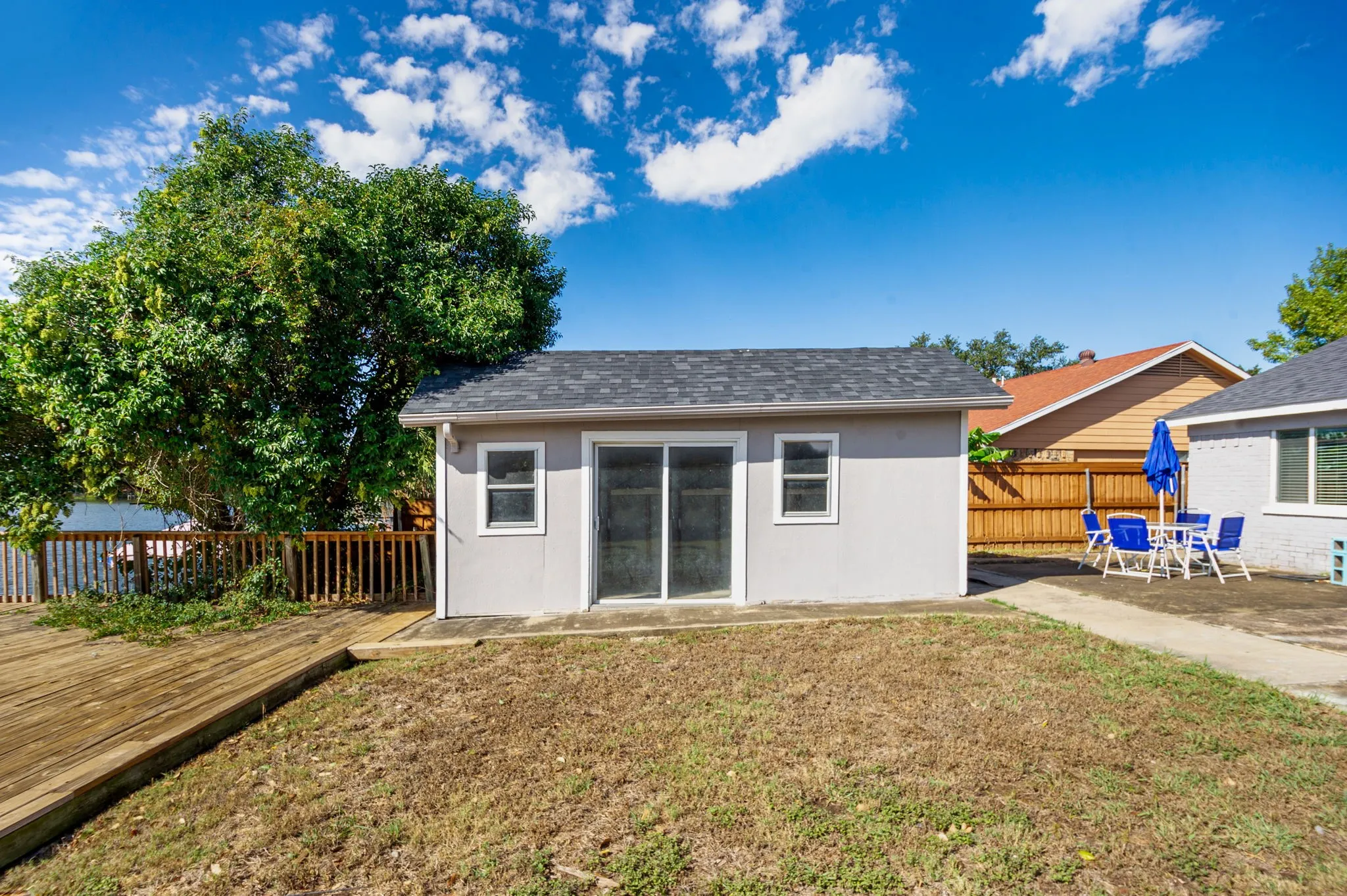 Detached structure with sliding glass doors and a shingle roof