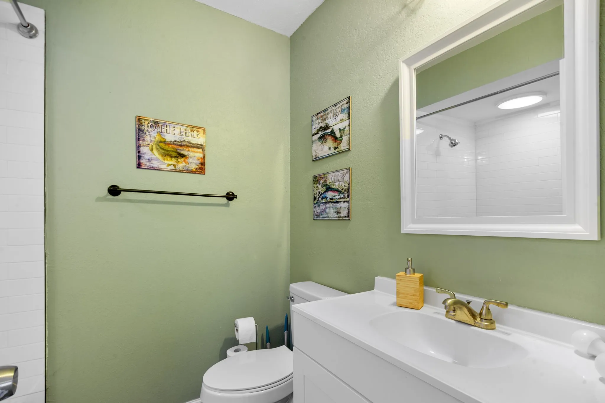 Vanity with integrated sink, gold-finish faucet, and coordinating framed mirror