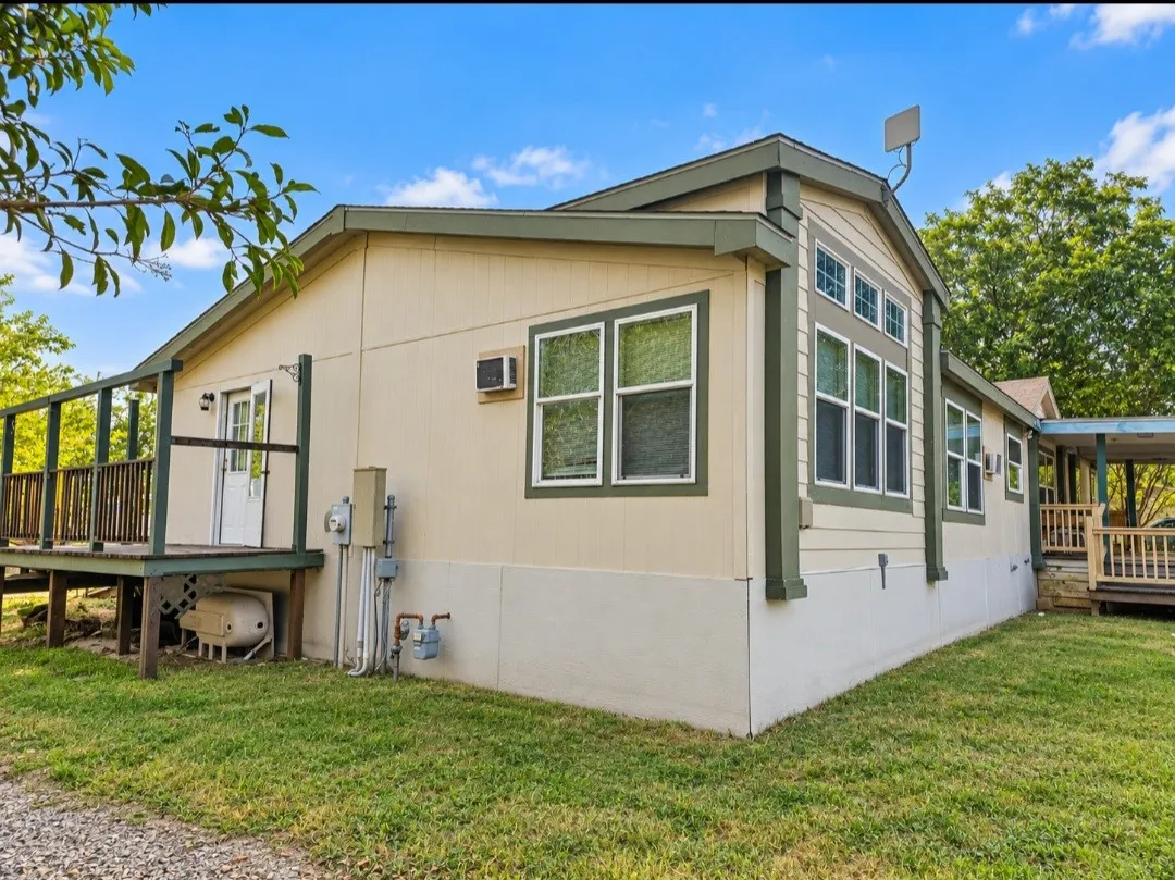 Exterior siding with contrasting trim, multiple window installations, elevated outdoor deck, and covered porch area