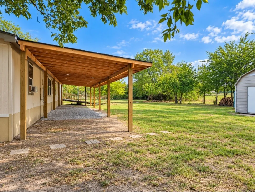 Extended covered patio with natural wood ceiling, gravel flooring, and recessed lighting