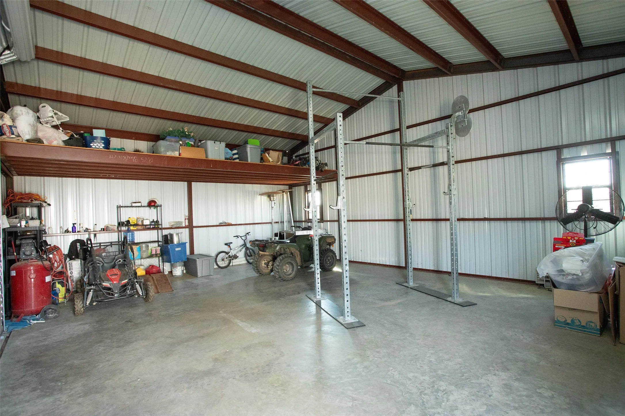 Metal-sided structure with exposed steel beams and a concrete floor