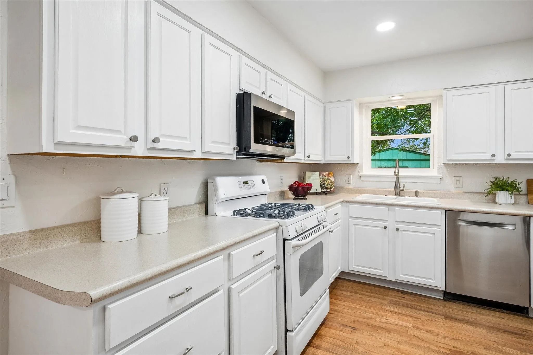 Abundance of crisp white cabinets and gas cooking with convection oven.