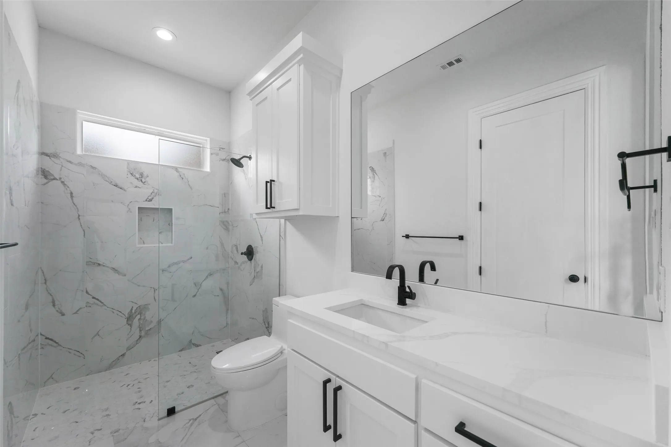 White vanity with a single basin sink, integrated countertop, and matte black faucet