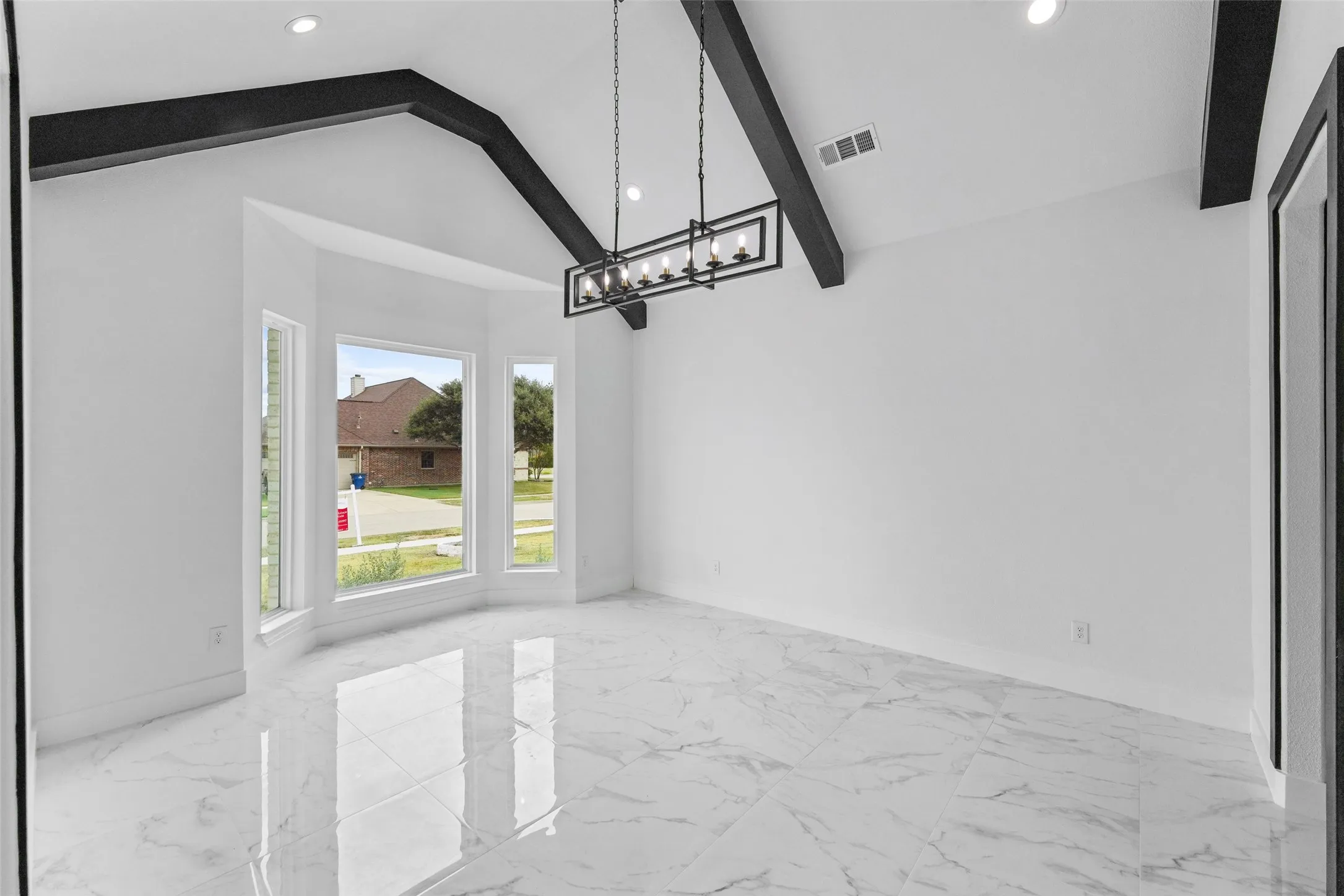 Vaulted ceiling with exposed beams, recessed lighting, bay windows, and polished tile flooring