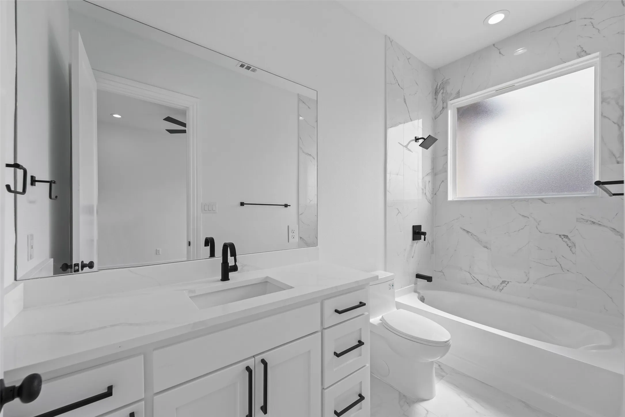 White vanity with matte black hardware, integrated sink, and white countertop