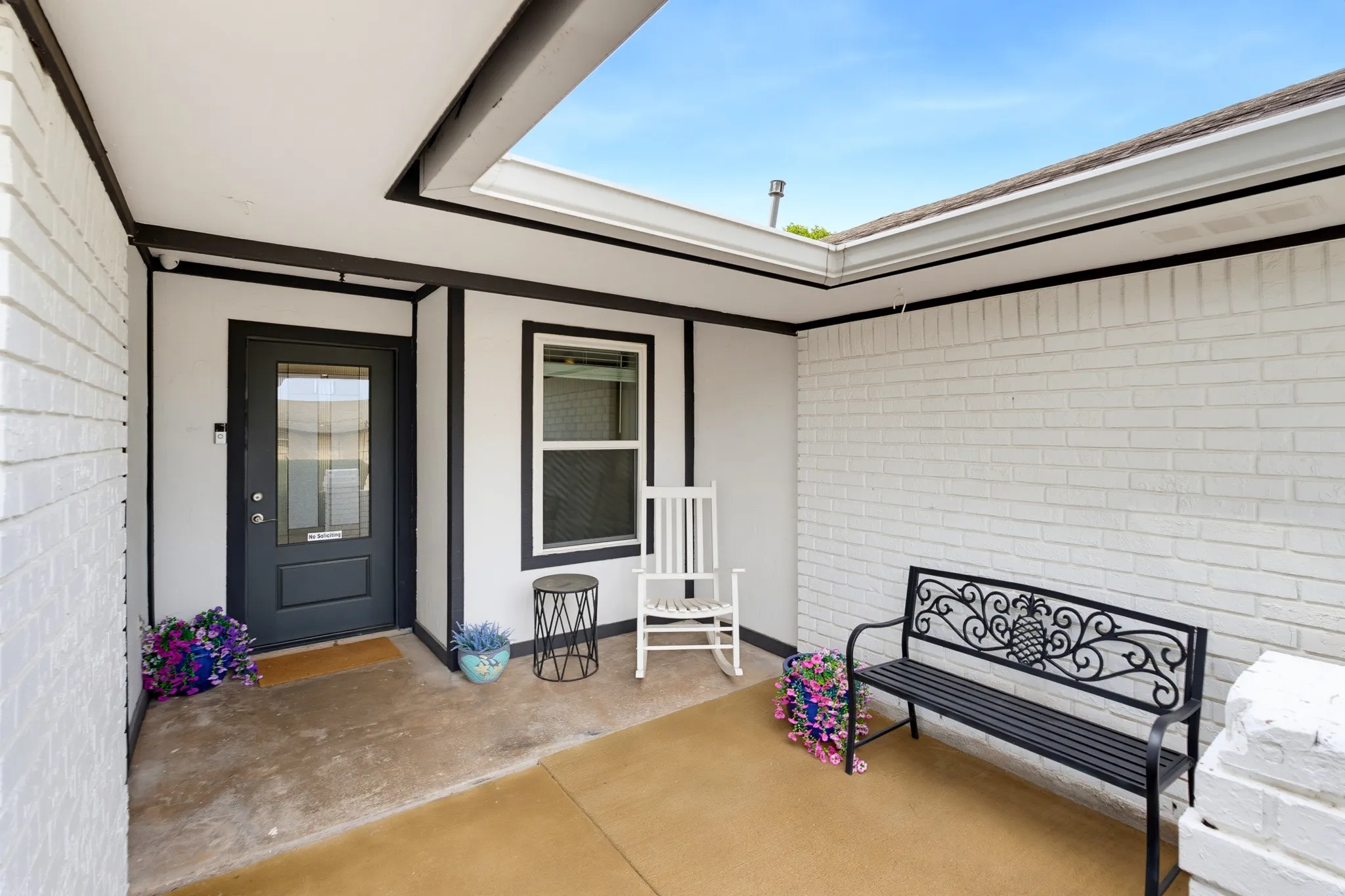 Covered entry with white painted brick and dark trim accents