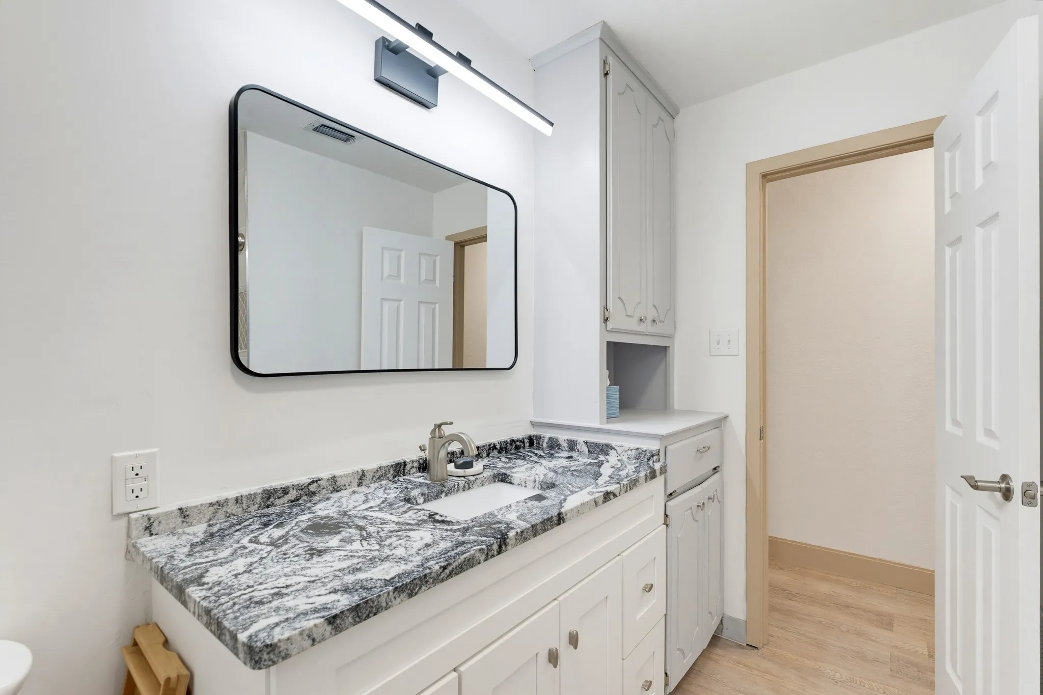 Vanity with a patterned countertop, undermount sink, and brushed nickel faucet