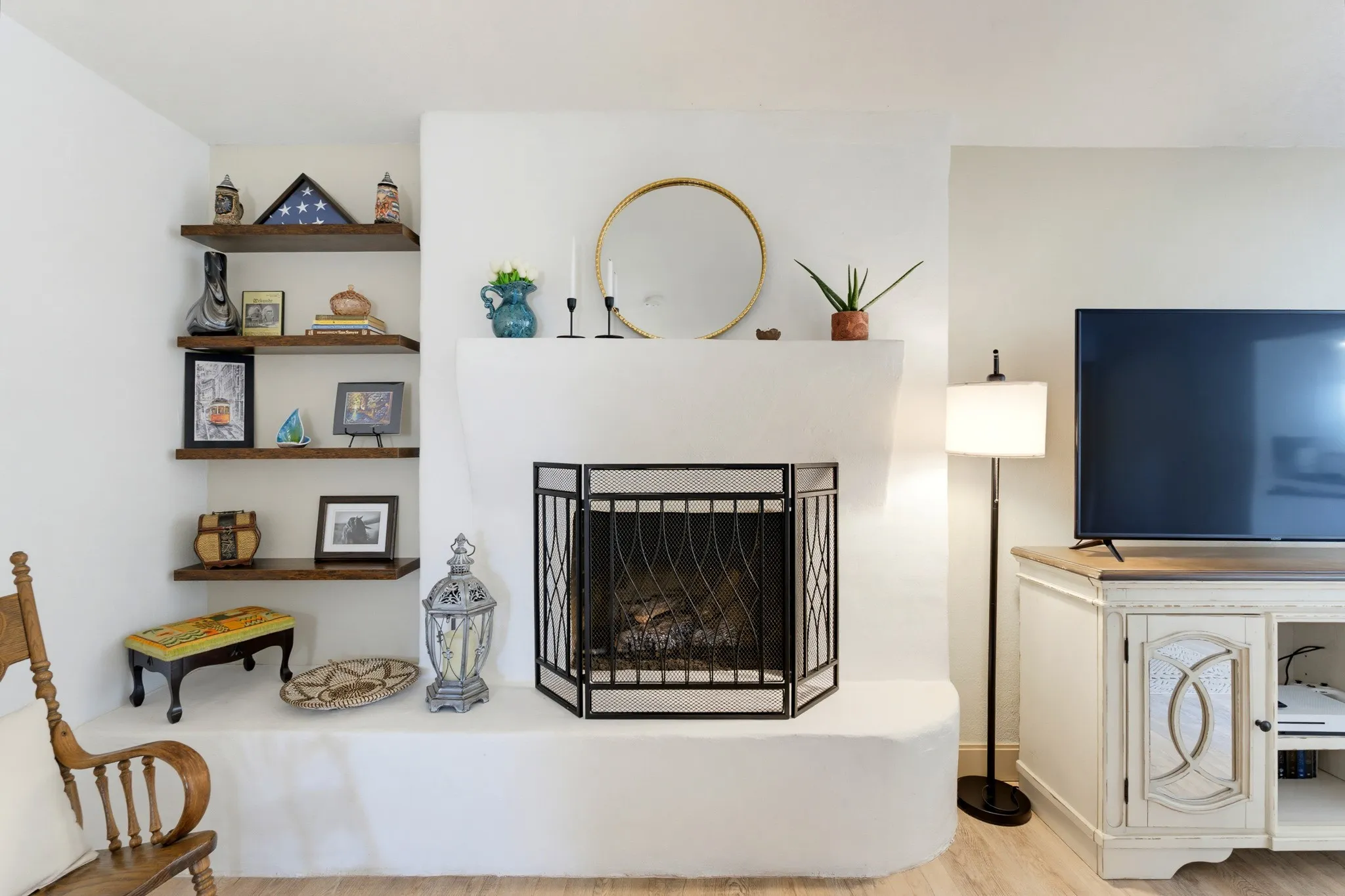Built-in corner shelving, integrated fireplace with screen, and light wood-finish flooring