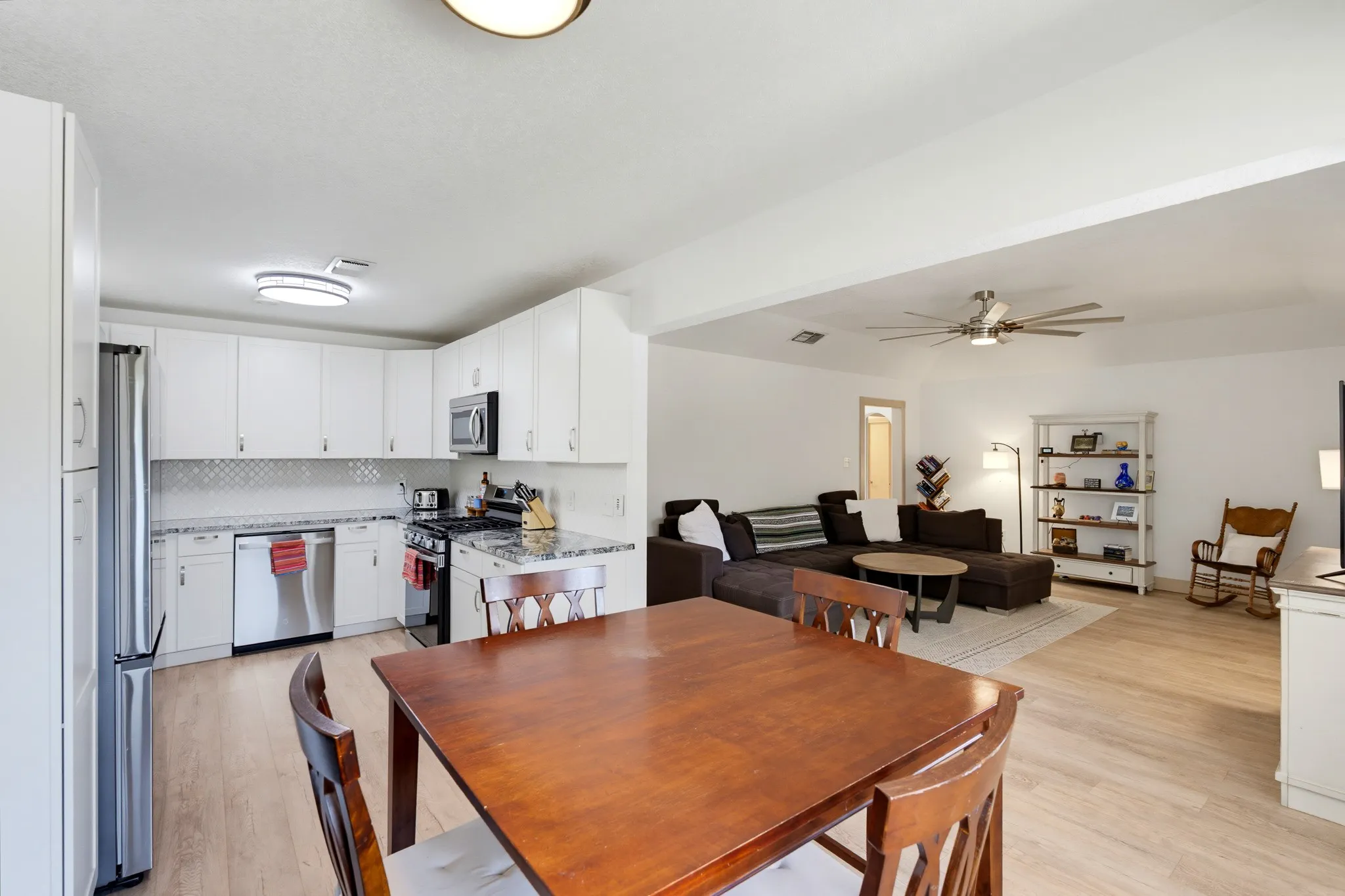 Modern kitchen with white cabinetry, stainless steel appliances, and a tiled backsplash