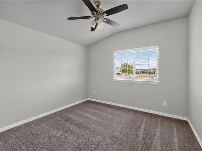Vaulted ceiling with a ceiling fan, neutral wall paint, window with blinds, and carpeted flooring