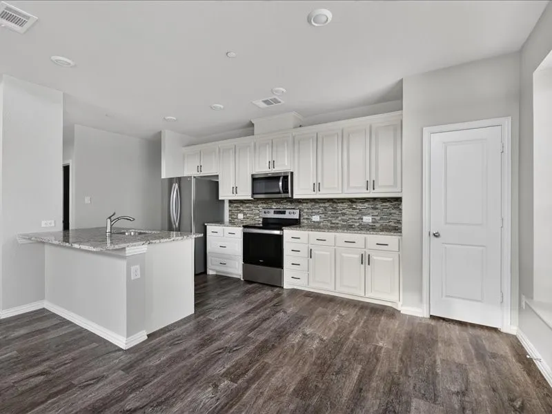 White cabinetry with dark hardware, stainless steel appliances, mosaic tile backsplash, and wood-finish flooring