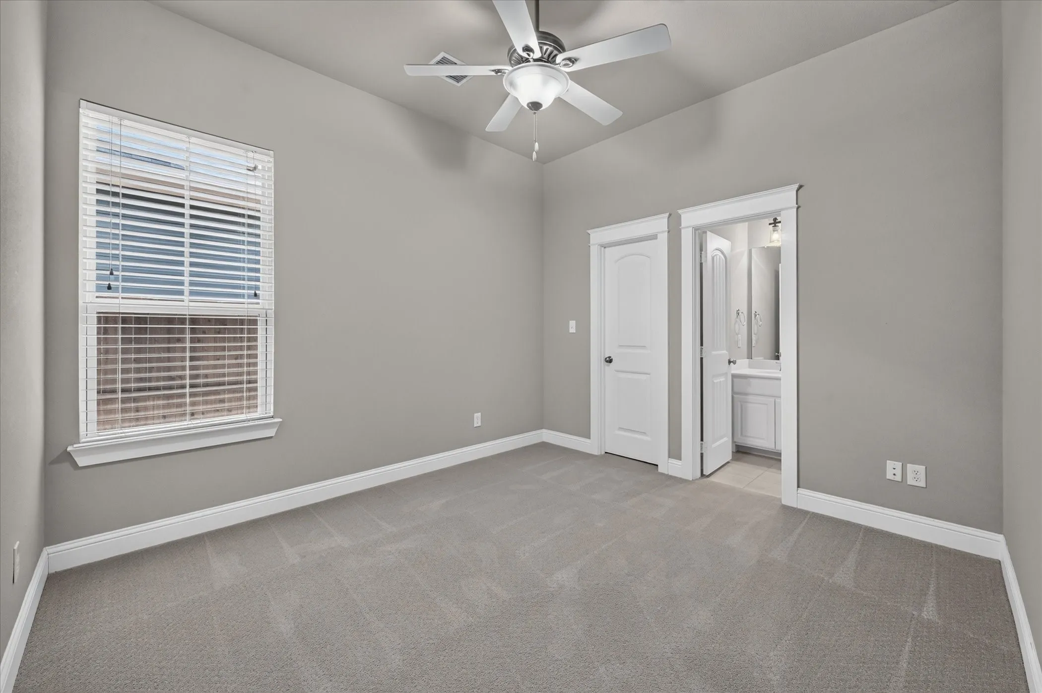 Carpeted room featuring a ceiling fan with integrated lighting, a window with blinds, and white trim