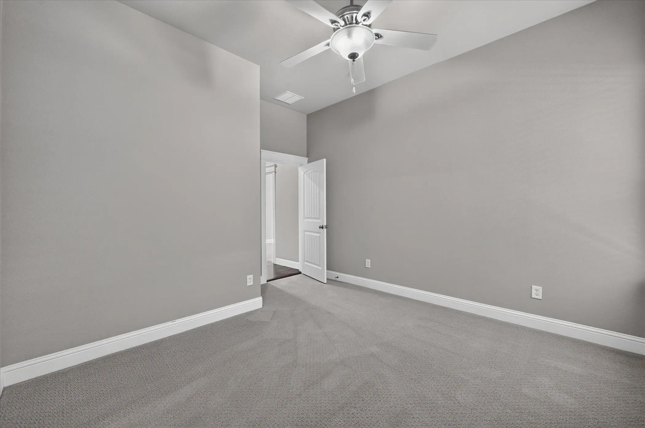 Neutral tone walls, plush carpeting, ceiling fan with integrated lighting, and white trim