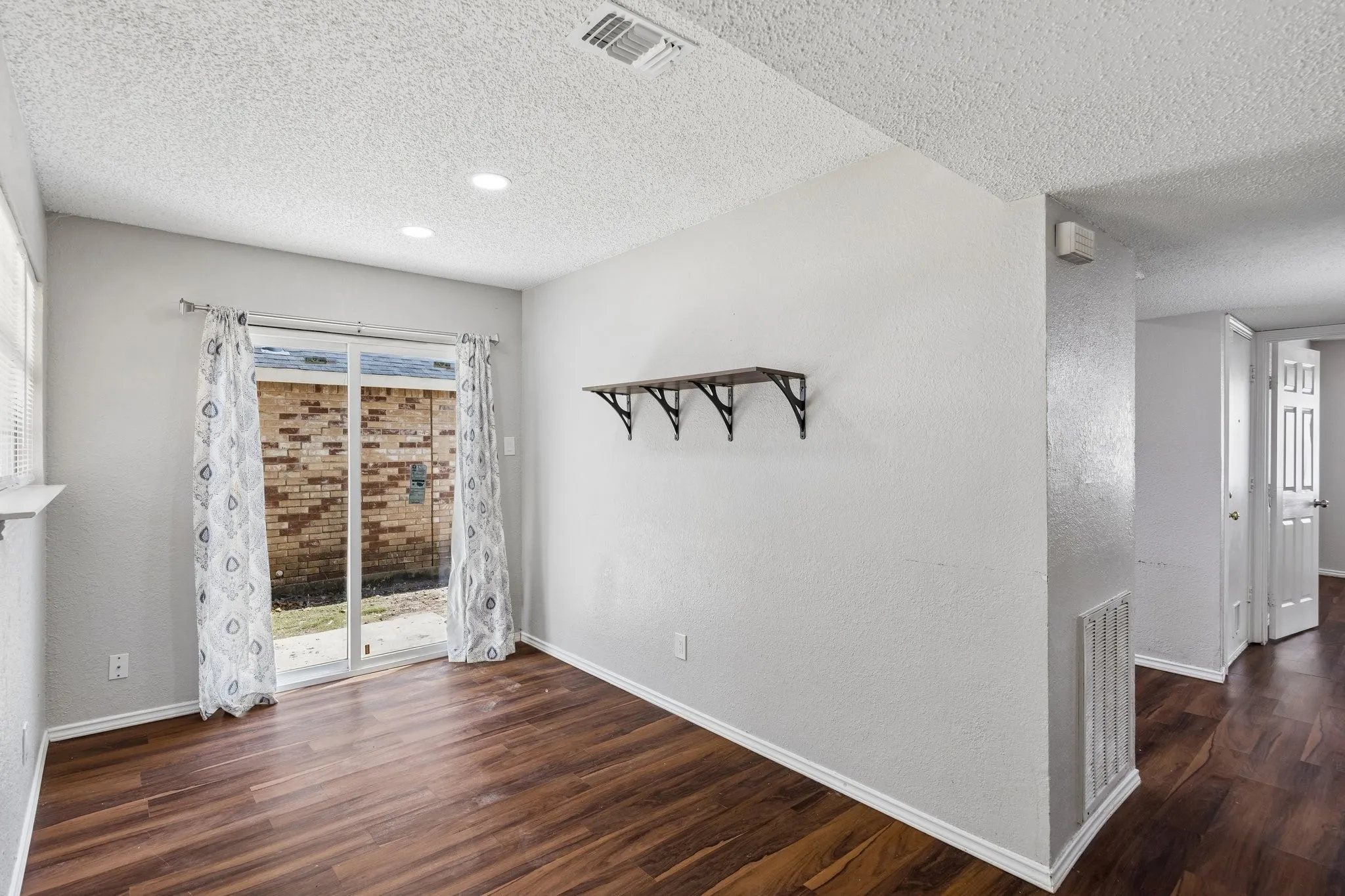 Wood-finish flooring, sliding glass door, recessed lighting, and built-in shelving