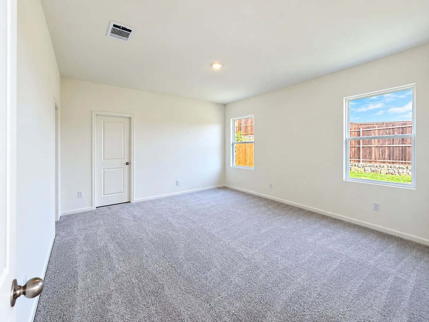 Neutral wall color with two windows and a flush-mount ceiling light