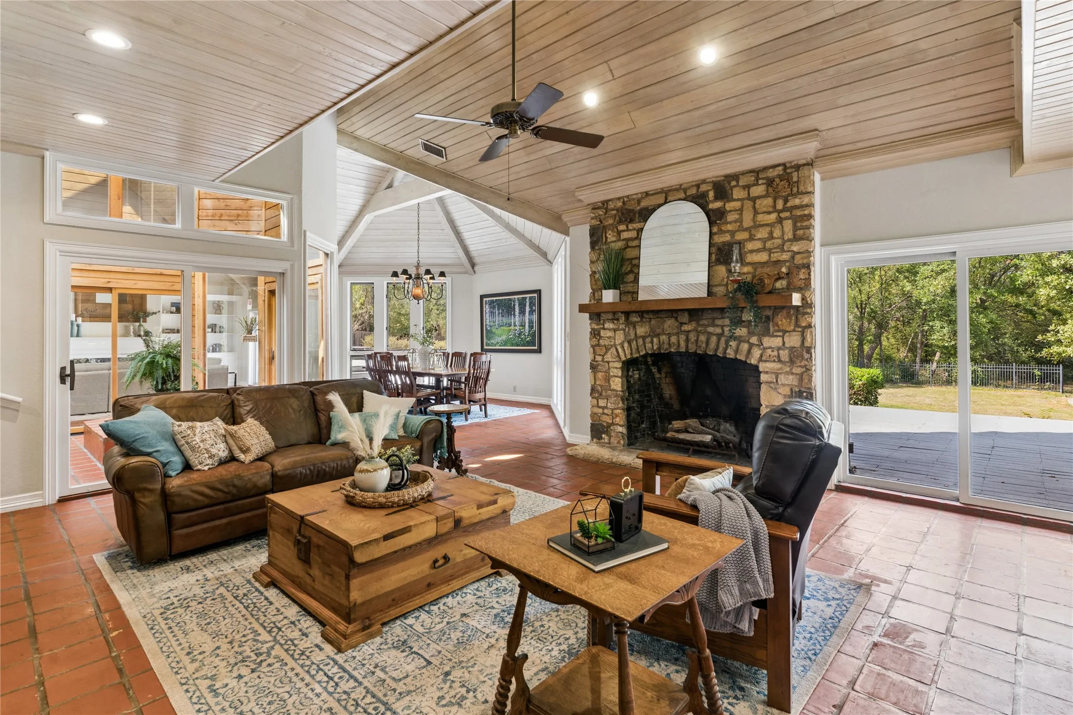 Spacious den is grounded by a stone wood burning fireplace.