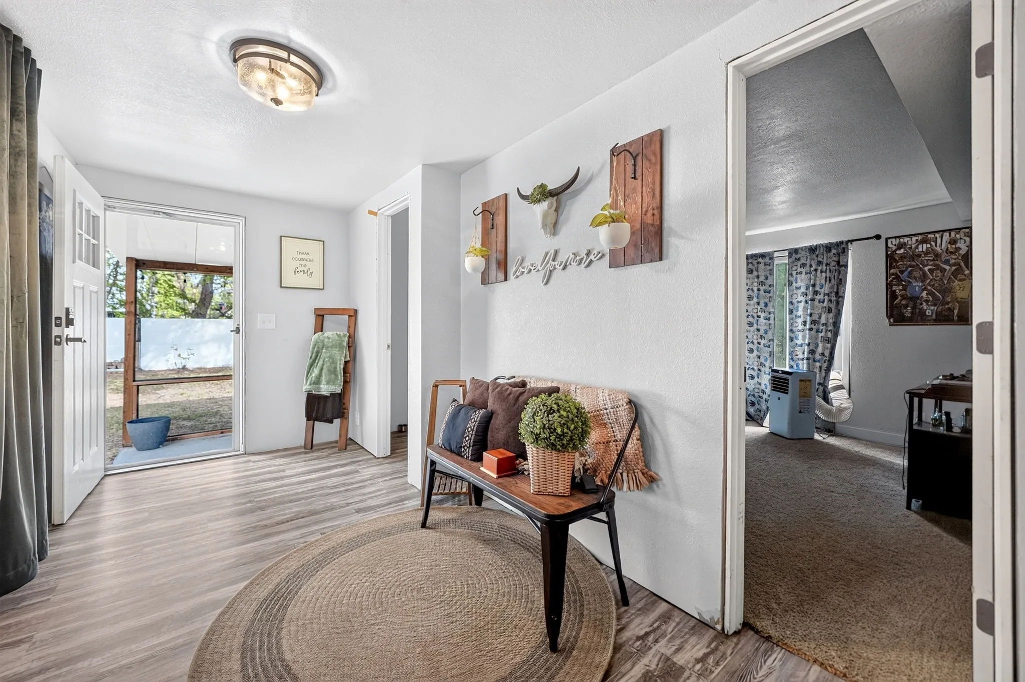 Wood-finish flooring, white walls, and an overhead flush-mount light fixture