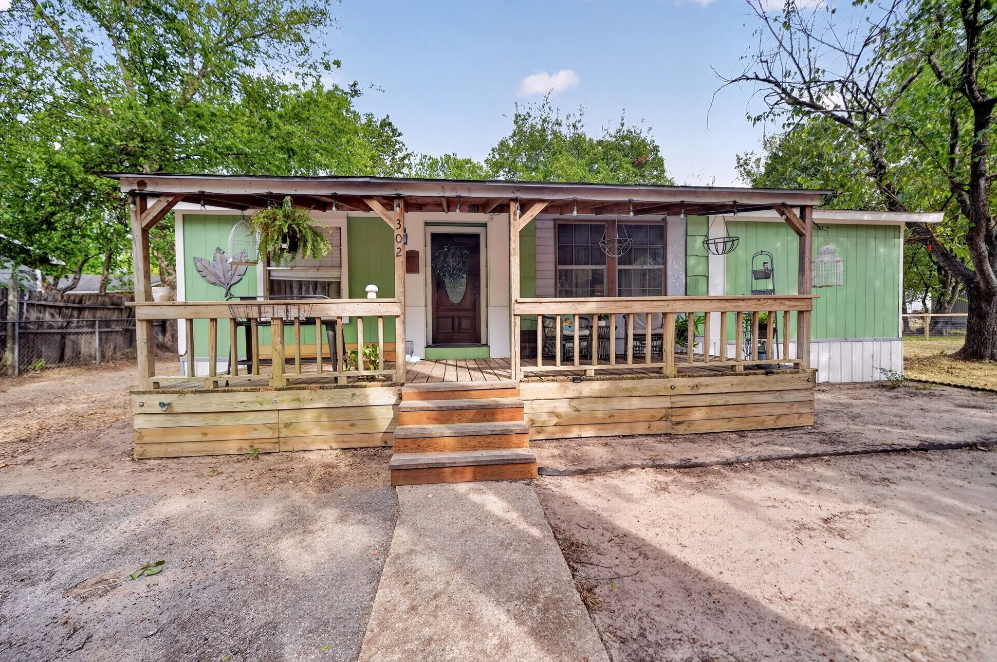 Covered front porch with wood railing and steps