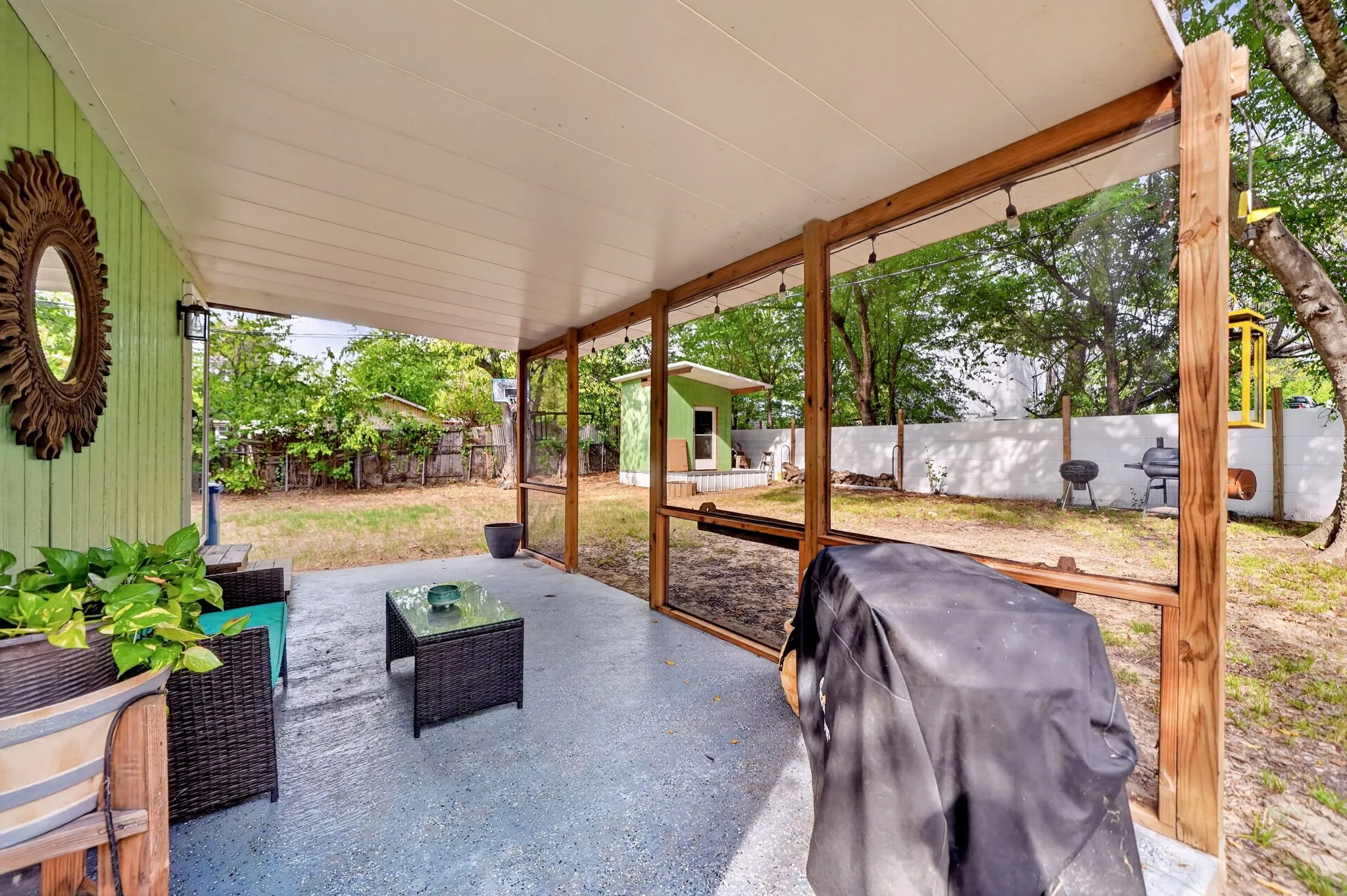 Covered patio featuring a solid roof, wood-beam supports, and a painted concrete floor