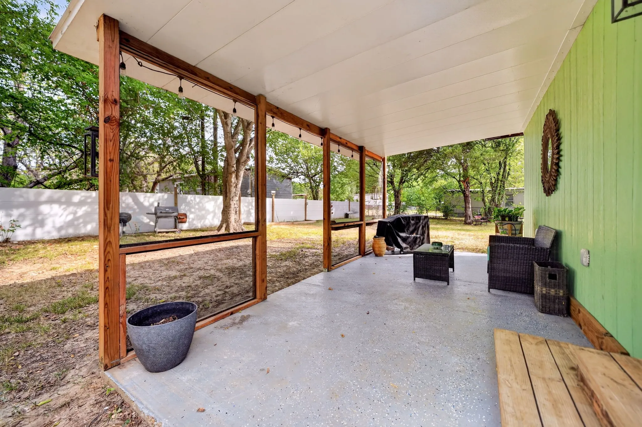 Covered patio with a concrete surface, wood-framed screen enclosure, and direct access to the backyard