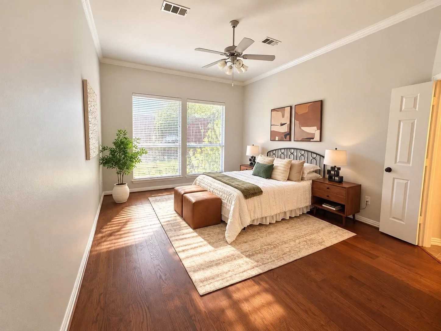Wood-finish flooring, crown molding, and a ceiling fan with integrated lighting