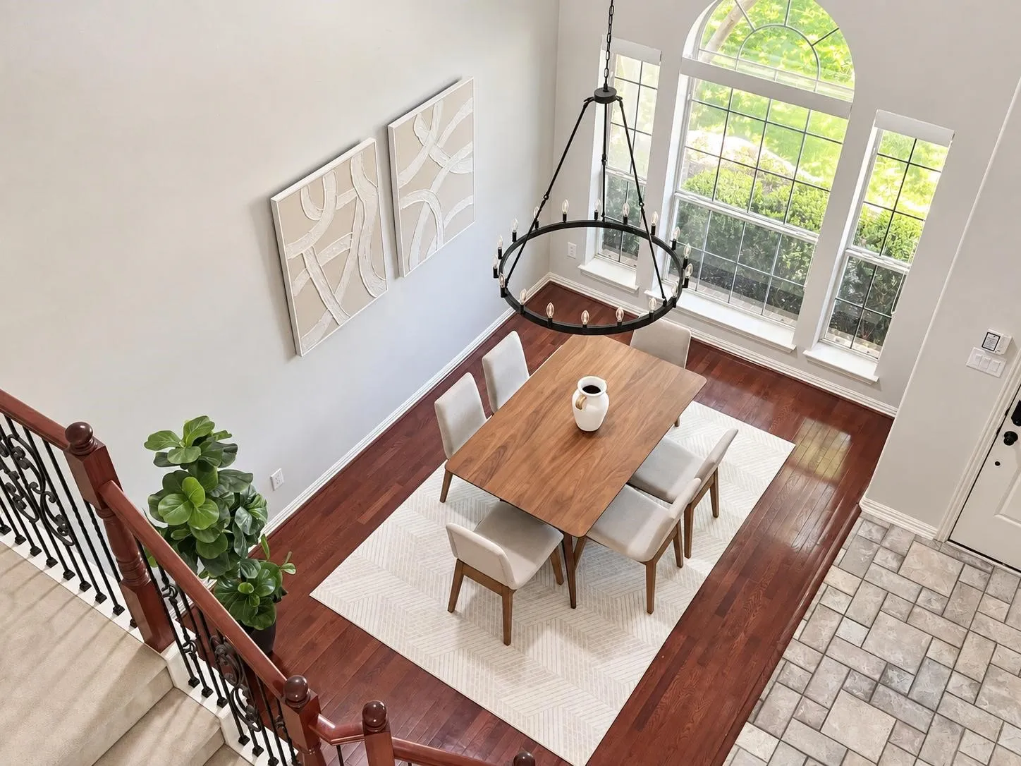 Two-story ceiling, arched window, wood-finish flooring, wrought iron chandelier, and tile flooring
