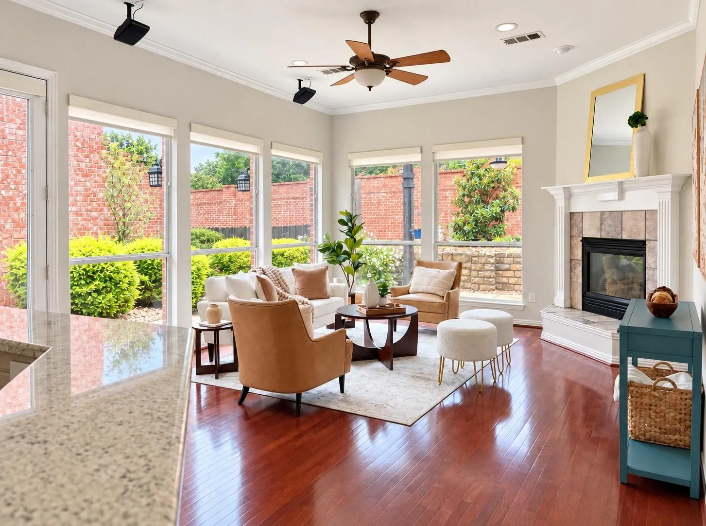 Living area featuring rich wood-finish flooring, a ceiling fan, and multiple windows